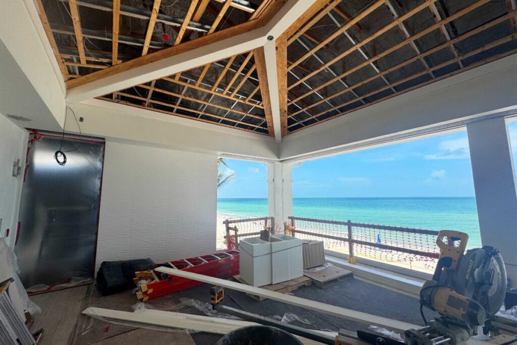 Ceiling beams are installed, with the tongue-and-groove ceiling pending.